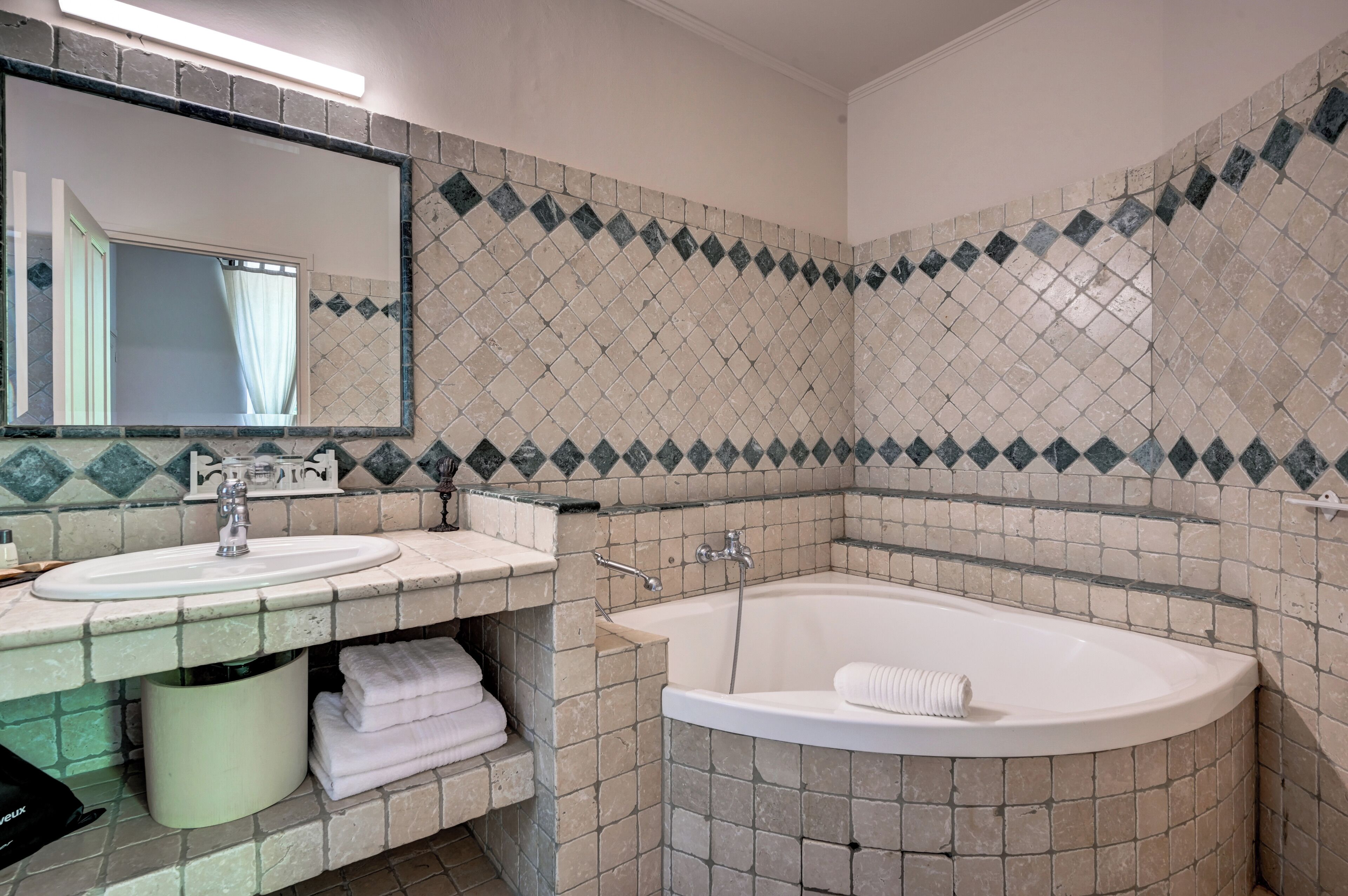 Un baño con dos lavamanos, una bañera y un espejo.