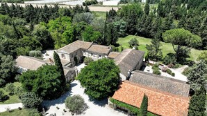 An aerial view of a historic building complex with multiple buildings, surrounded by lush greenery and a well-maintained courtyard. - Mas des Comtes de Provence (Tarascon)