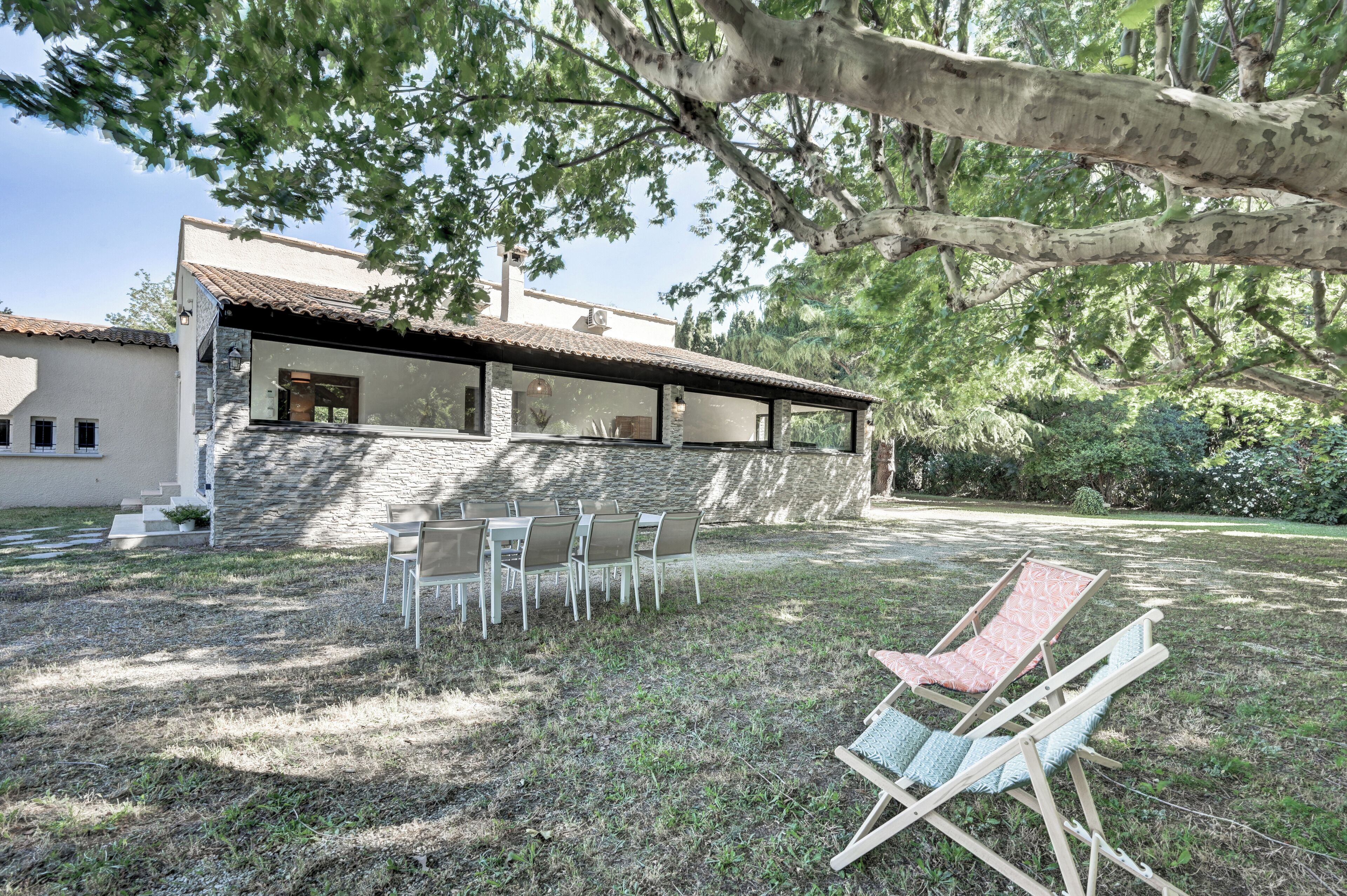 Una casa con una escalera de piedra que conduce a un porche cubierto con mobiliario exterior.
