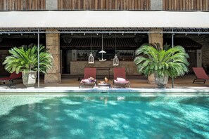 A poolside area with lounge chairs, a bar, and decorative lighting. - Mas des Comtes de Provence  (Tarascon)