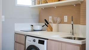 Una cocina moderna con lavavajillas, un lavaplatos y una encimera con utensilios de cocina.