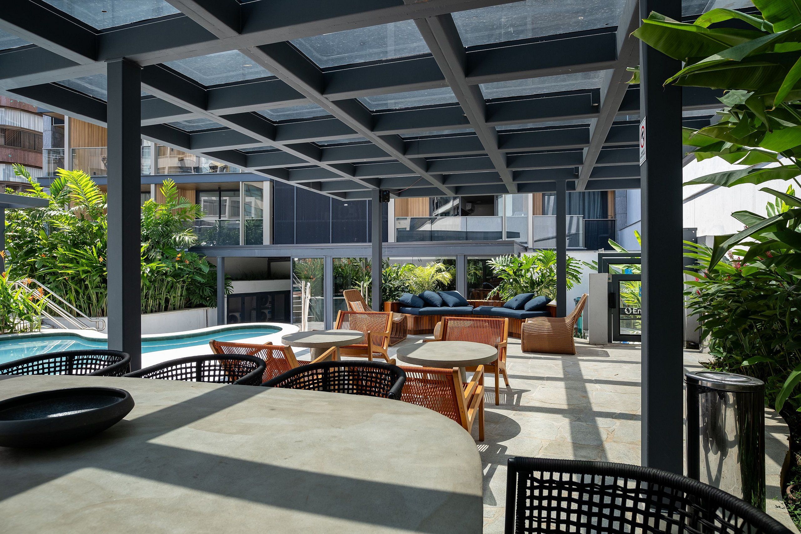 An outdoor patio area with seating, a pool, and a view of the surrounding buildings.
