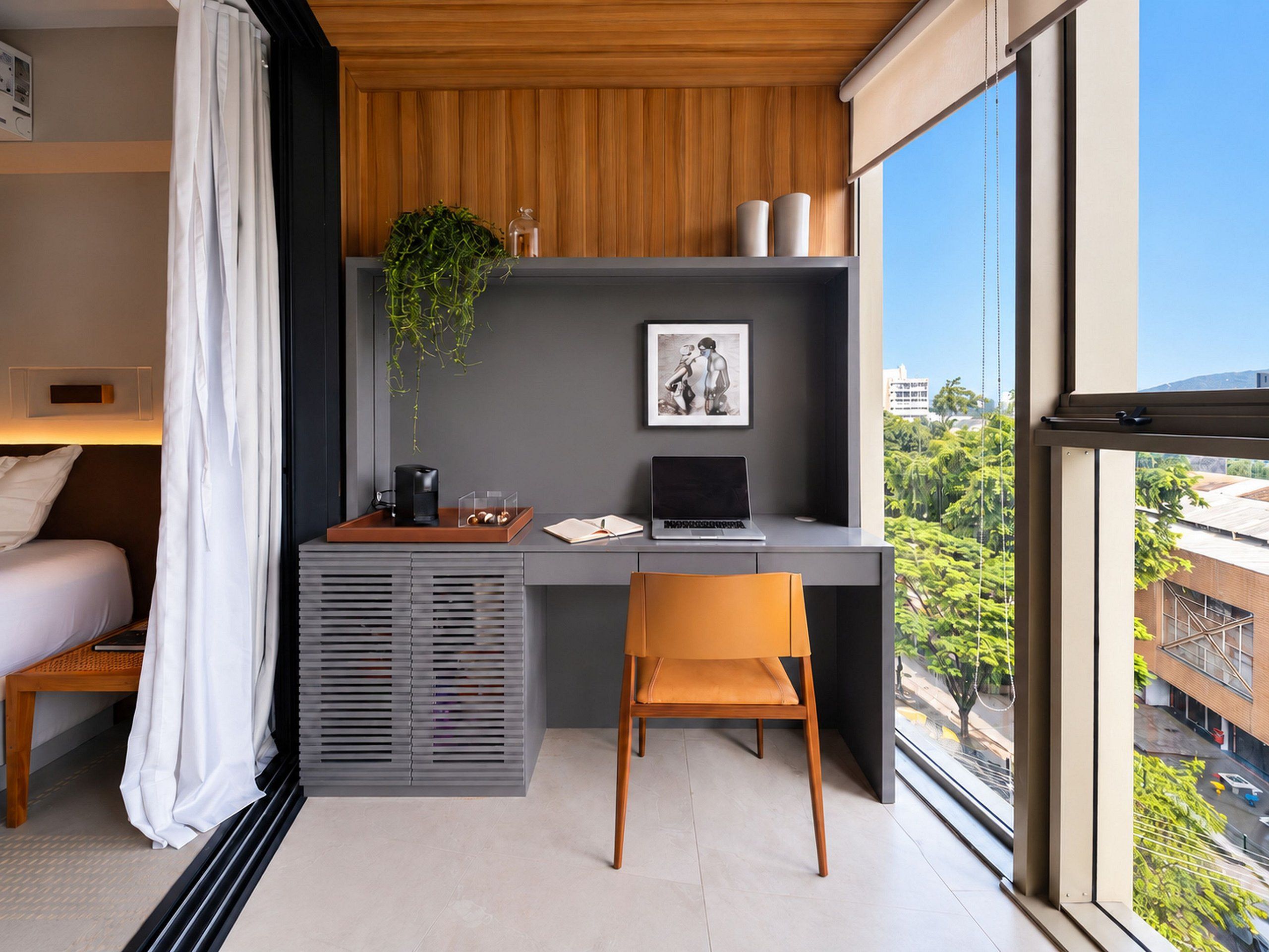 Un dormitorio moderno con cama, escritorio y silla. Se ve una ventana con vistas a edificios y árboles.