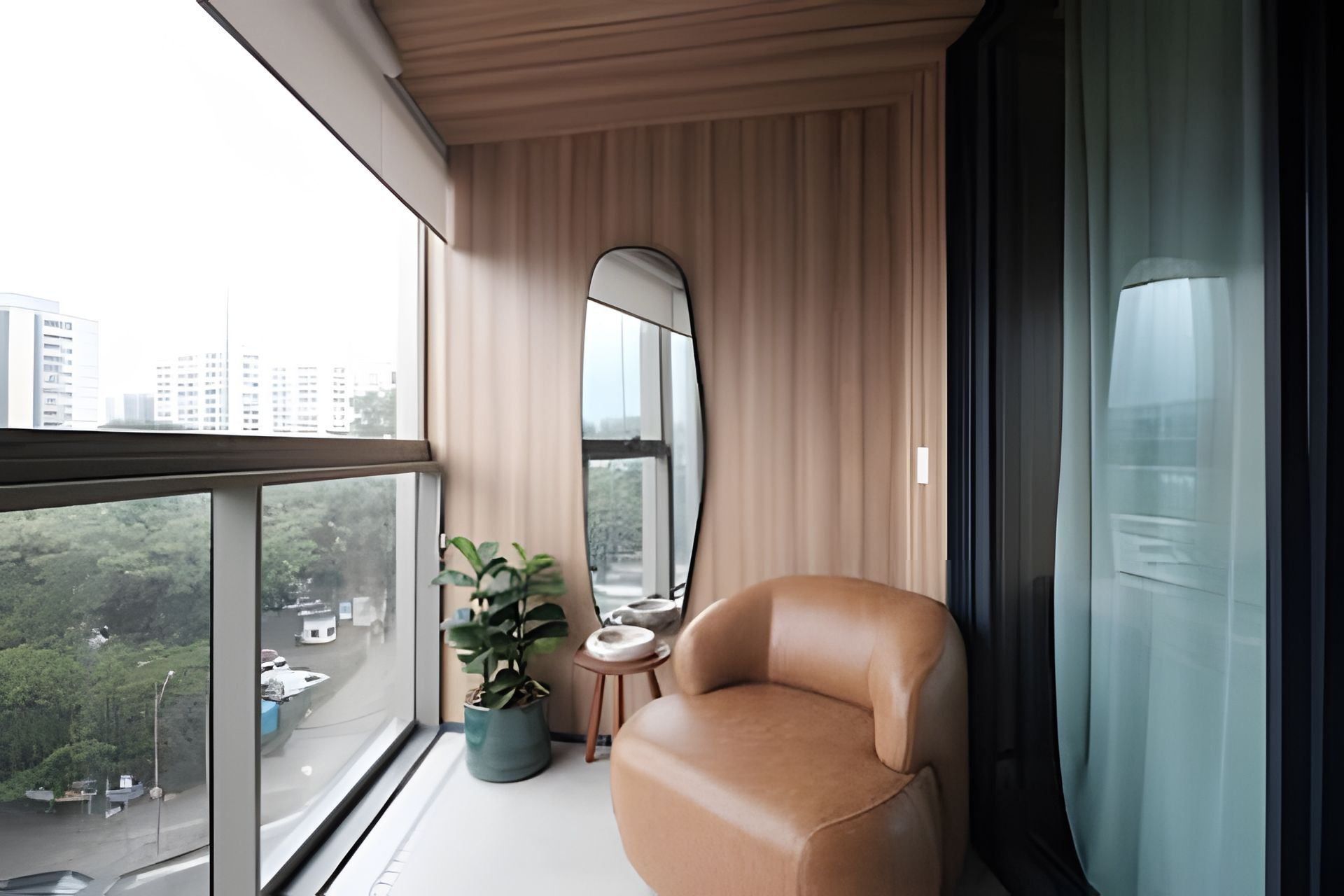 A modern balcony with a leather chair, a potted plant, and a view of a cityscape.