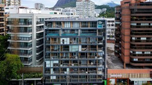 A multi-story building with balconies, large windows, and a rooftop terrace. - Leblon | Loft 5 min da Praia, com varanda vista Cristo - por Casapē Rio (Rio de Janeiro)