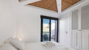A bedroom with a bed, pillows, and a view of a balcony. - Villa - Canas da Ria - Private Pool (Santa Luzia)