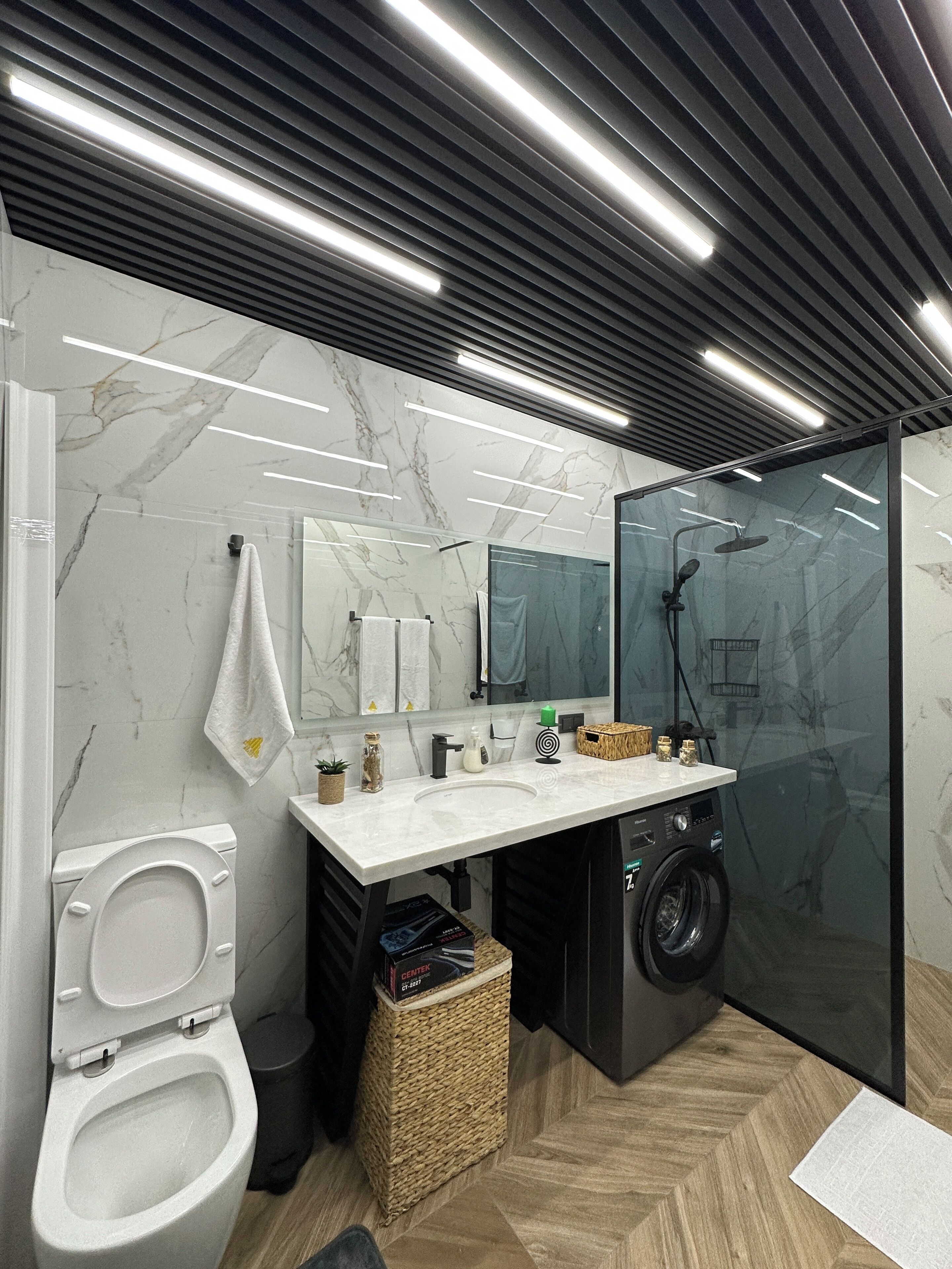 A modern bathroom with a toilet, sink, and shower.