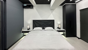 Un dormitorio moderno con una cama grande, mesitas de noche y un armario.