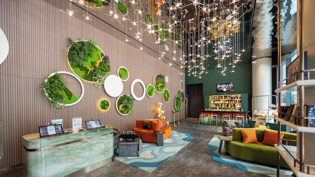 A reception area with a marble counter, seating with cushions, a bar, and a bookshelf. - Hotel Waterloo Singapore - Handwritten Collection (Singapore)