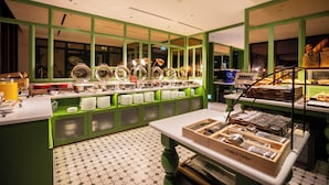 A buffet area with green cabinets, a white table, and a tiled floor. - Hotel Waterloo Singapore - Handwritten Collection (Singapore)