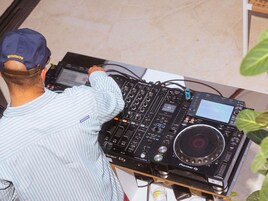Une console de DJ Pioneer DJ dotée d’un écran, de boutons rotatifs et de boutons poussoirs.