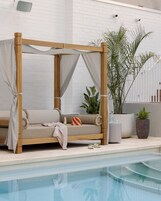 Una piscina al aire libre, sombrillas, sillones reclinables de piscina