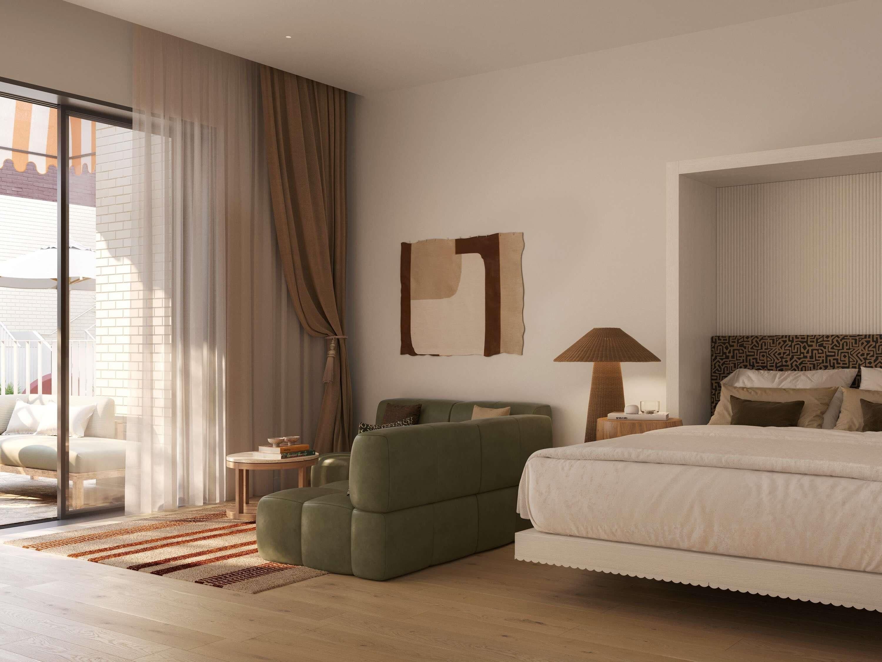 A modern hotel room with a large bed, a green armchair, a small side table, and a large window with curtains.