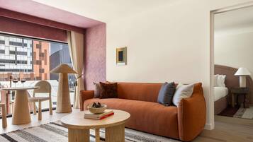 Uma sala de estar moderna com um sofá, mesa de centro e um espaço de refeições com cadeiras e uma mesa.