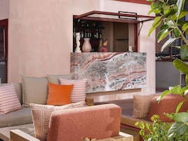 A seating area with a sofa, cushions, and a marble artwork.