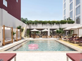 Una piscina al aire libre, sombrillas, tumbonas