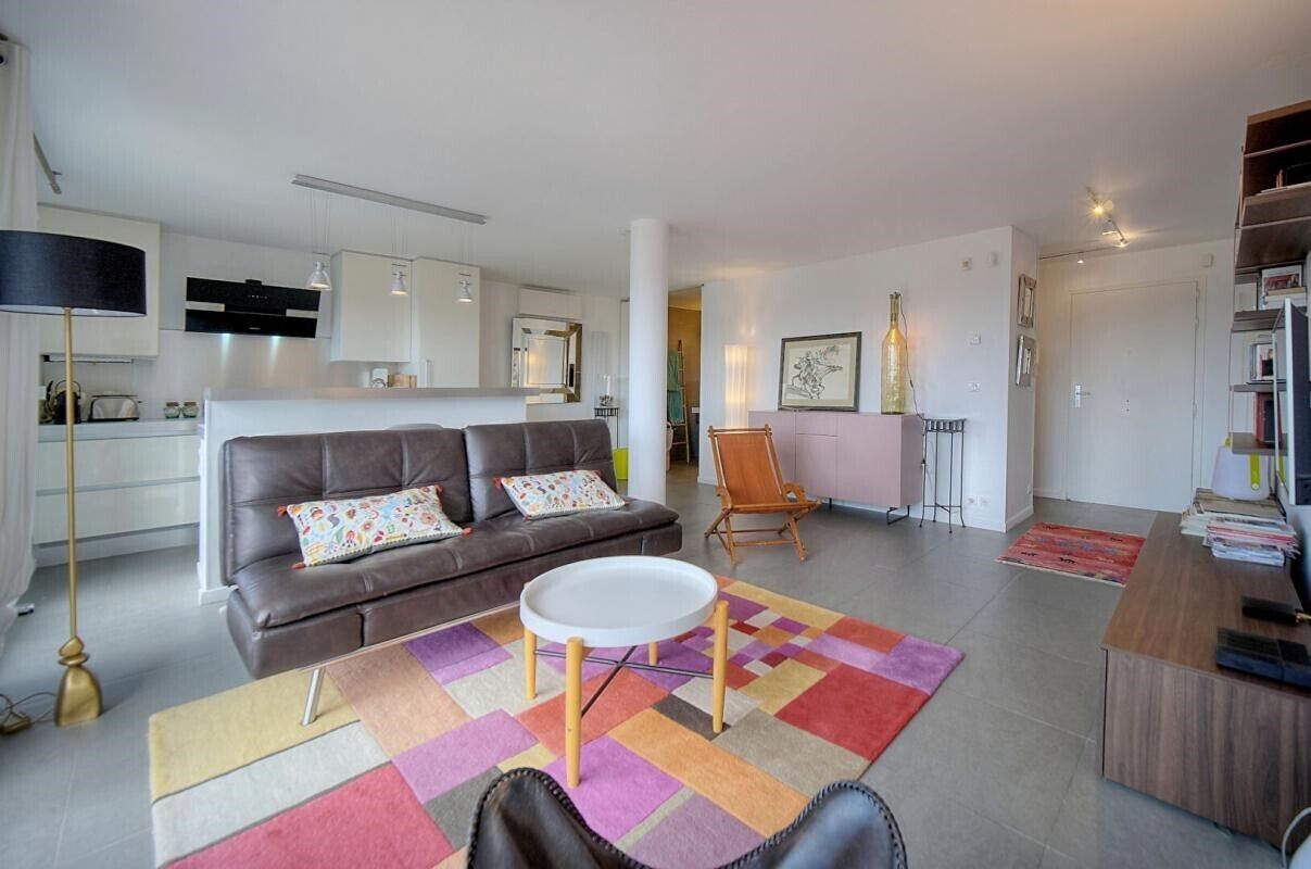 Un salon moderne avec un canapé, une table basse et un tapis aux couleurs vives.
