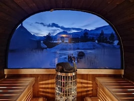 Una sauna con bancos de madera y un ventanal grande.