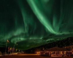 Un edificio con un porche cubierto y un área cercada.