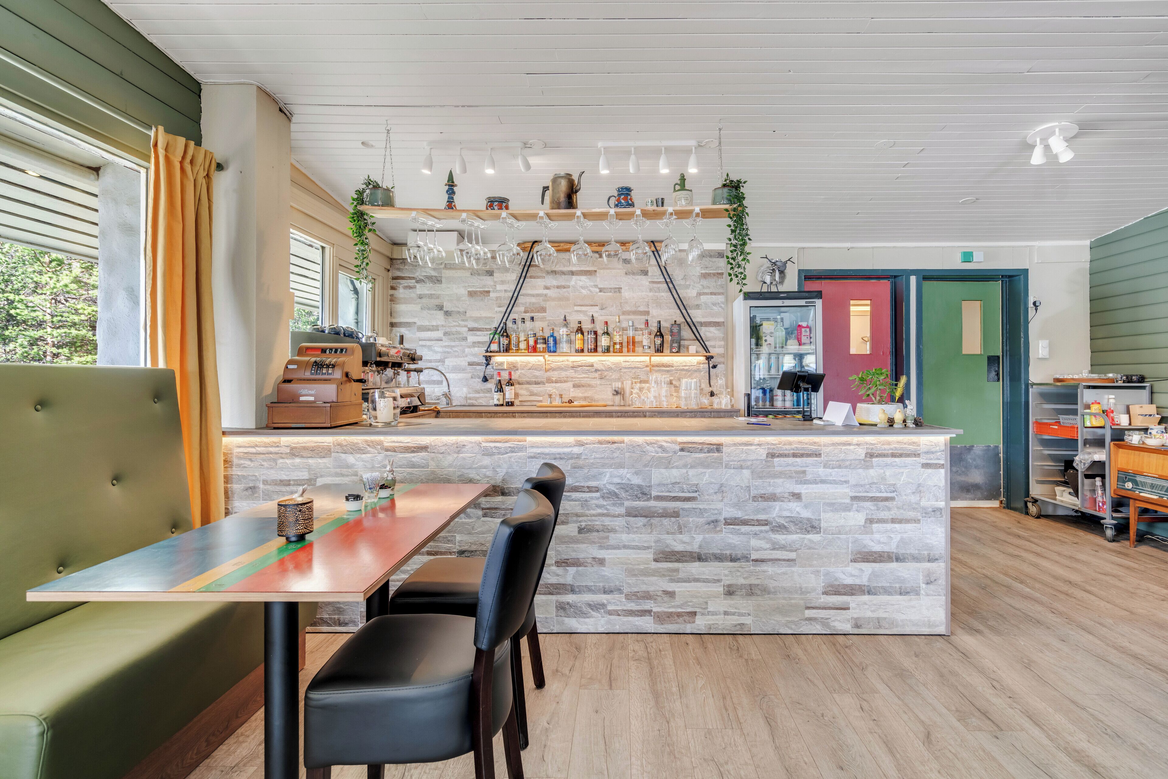 A restaurant with a stone counter, bar area, and seating.
