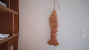 A room with a wooden bookshelf and a hanging decorative piece.