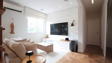 Een moderne woonkamer met een bank, salontafel en een klein houten bijzettafeltje.