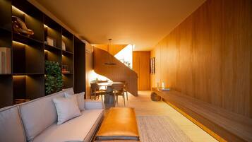 Een modern interieur met een bank, eettafel en houten lambrisering.