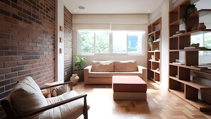 A modern living room with a brick wall, a sofa, a coffee table, and a bookshelf. - Leblon | Recém reformado, 2 quartos, 5 min da Praia – por Casapē Rio (Rio de Janeiro)