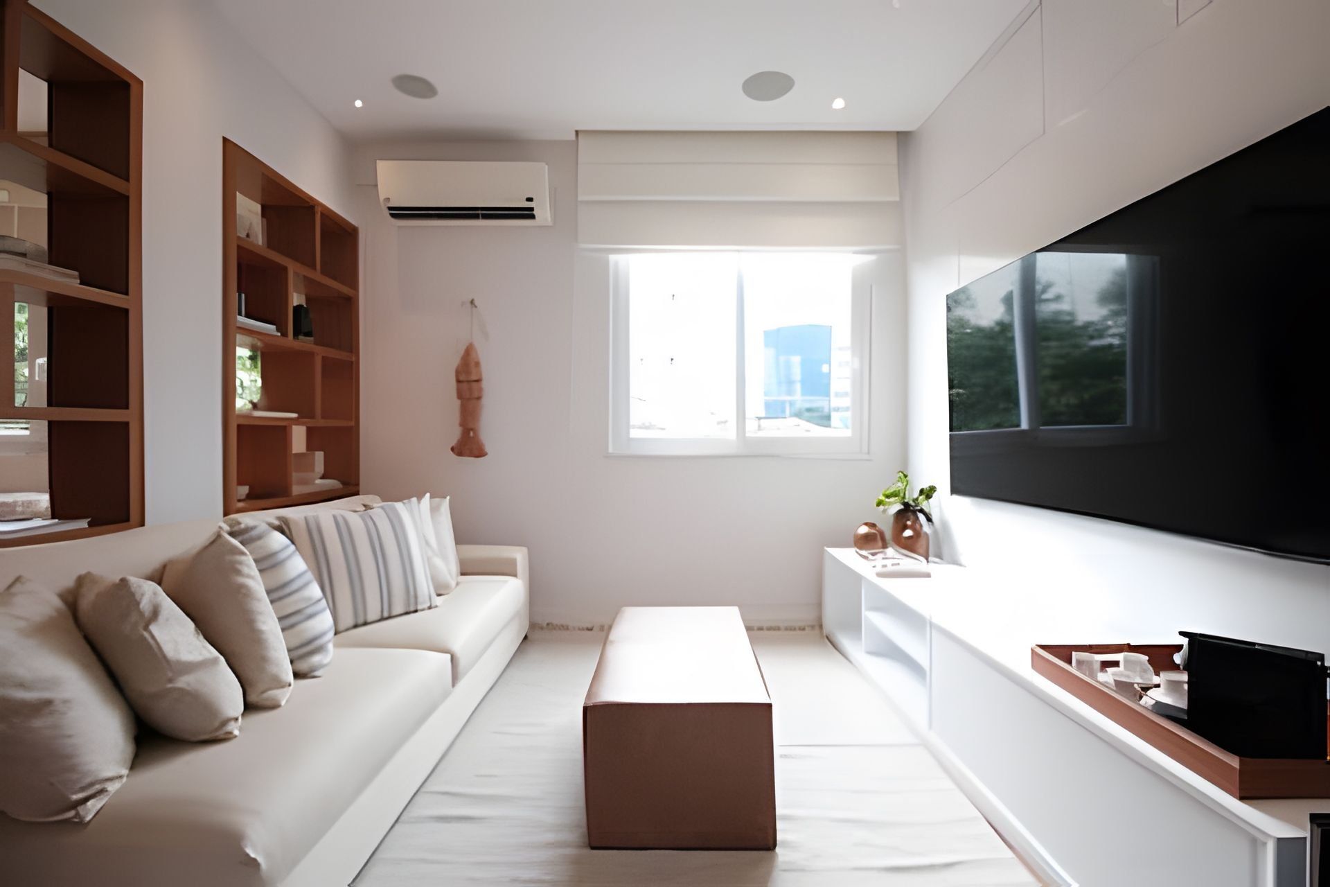 Un soggiorno moderno con un divano bianco, una televisione a schermo piatto, una libreria in legno e una finestra con vista sulla città.