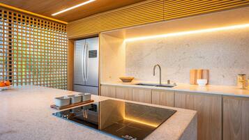 A modern kitchen with a built-in stove, a refrigerator, and a sink.