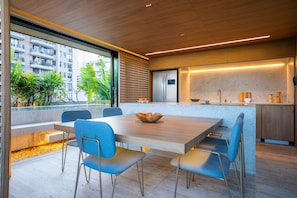 Une cuisine moderne dotée d’un îlot central, d’appareils électroménagers intégrés et offrant une vue sur la ville.