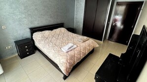 A bedroom with a bed, a dresser, a wardrobe, and a nightstand. - Fully-equipped studio, pool view. (Agadir)