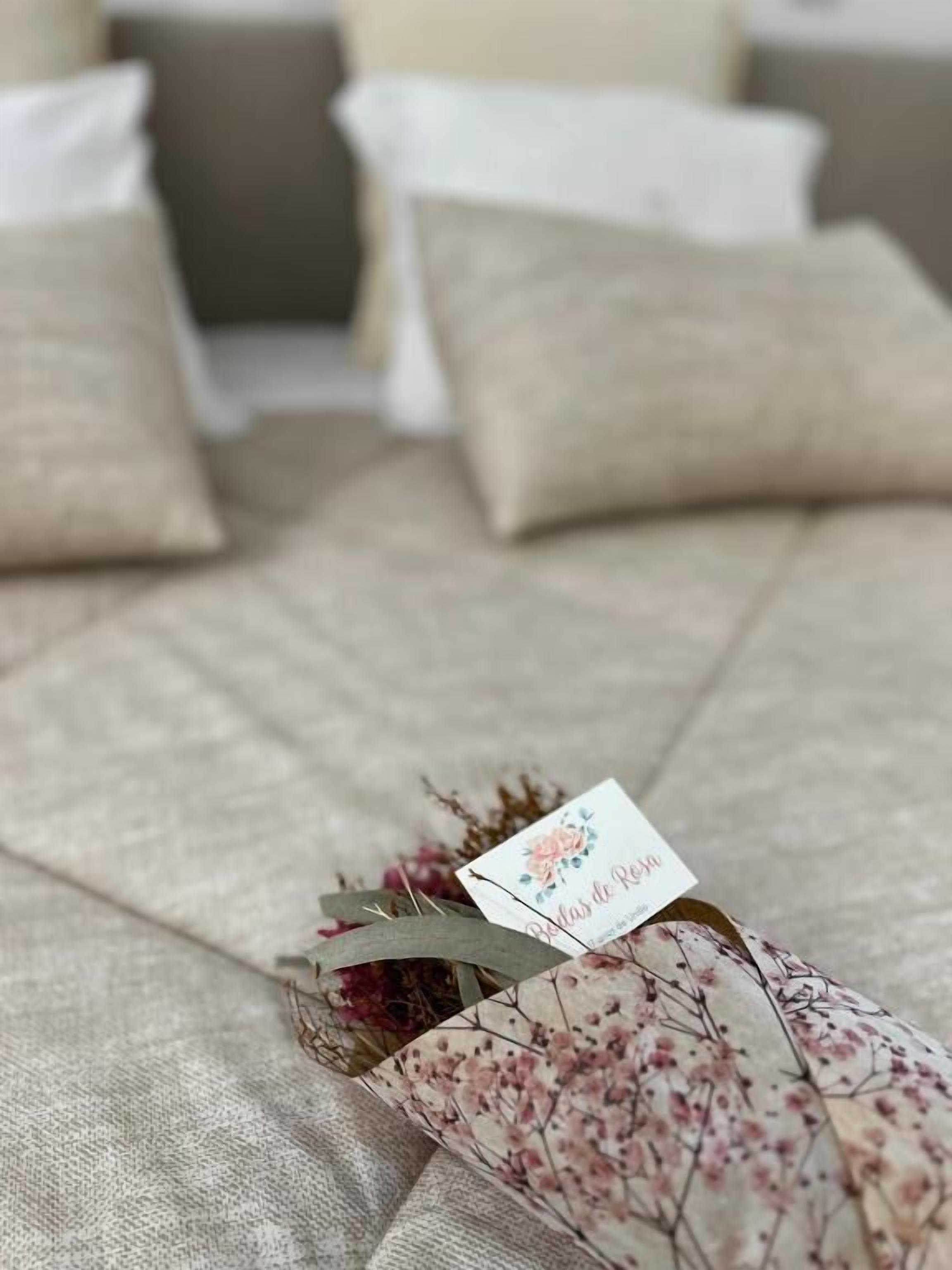 Una cama con ropa de cama de estampado floral y una etiqueta que dice "Bodas de Rio".