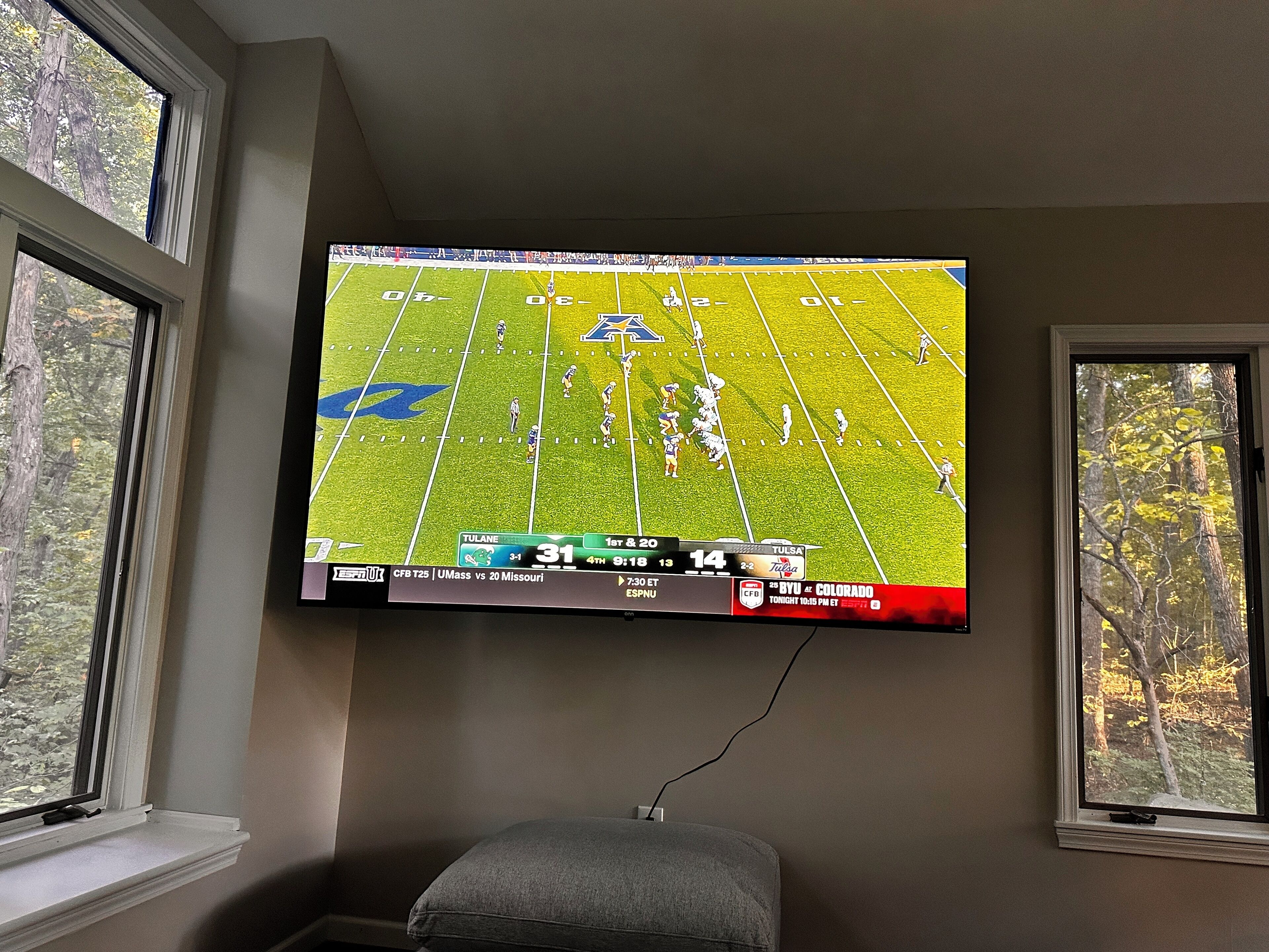 Un televisor montado en la pared mostrando un partido de fútbol.