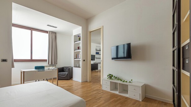A modern bedroom with a bed, a desk, a TV, and a wardrobe. - Vetro Apartment by Wonderful Italy  (Palermo)
