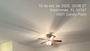 Uma sala de estar moderna com um sofá seccional, uma mesa de centro e um ventilador de teto.
