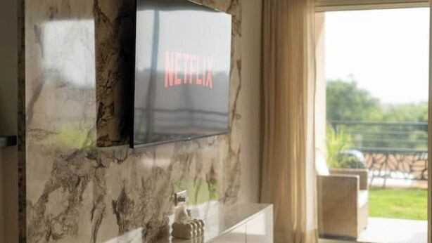 A television mounted on a wall with a marble pattern.