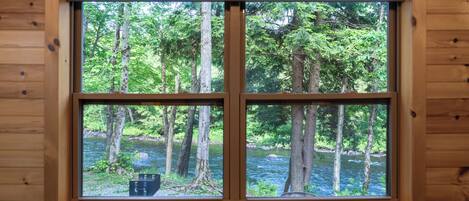 Una ventana con vistas a un bosque y un río.
