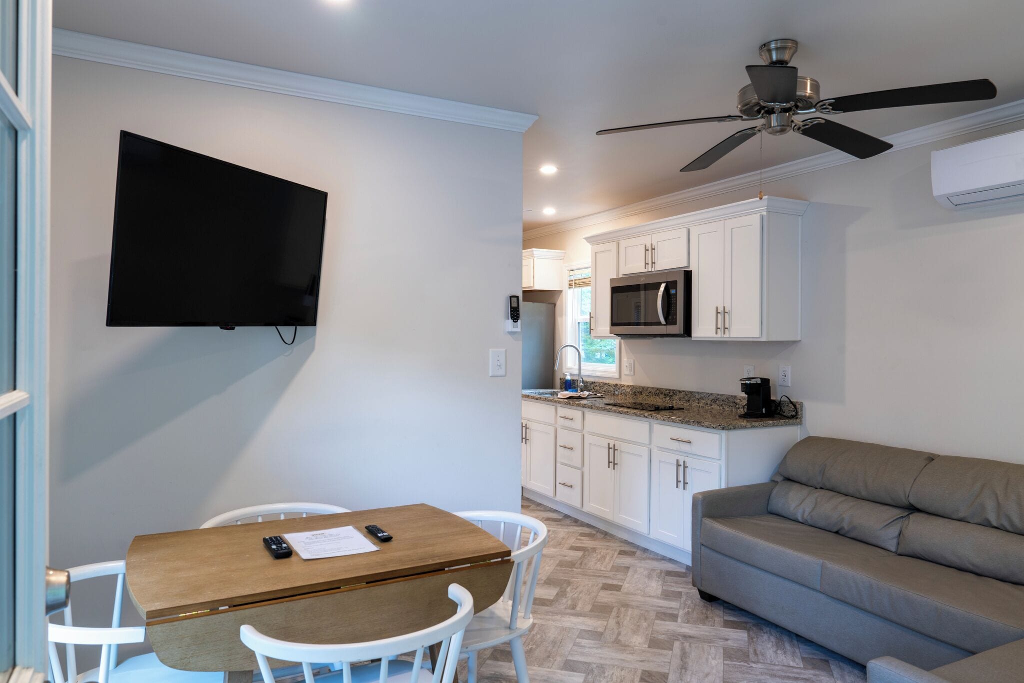 Un espace de vie compact comprenant un coin repas, une kitchenette et un canapé.