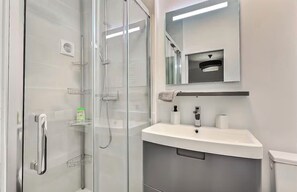 Chuveiro, toalhas de banho, sabonete, papel higiênico