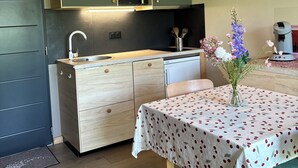 Una cocina compacta con microondas, pileta y armarios de madera.
