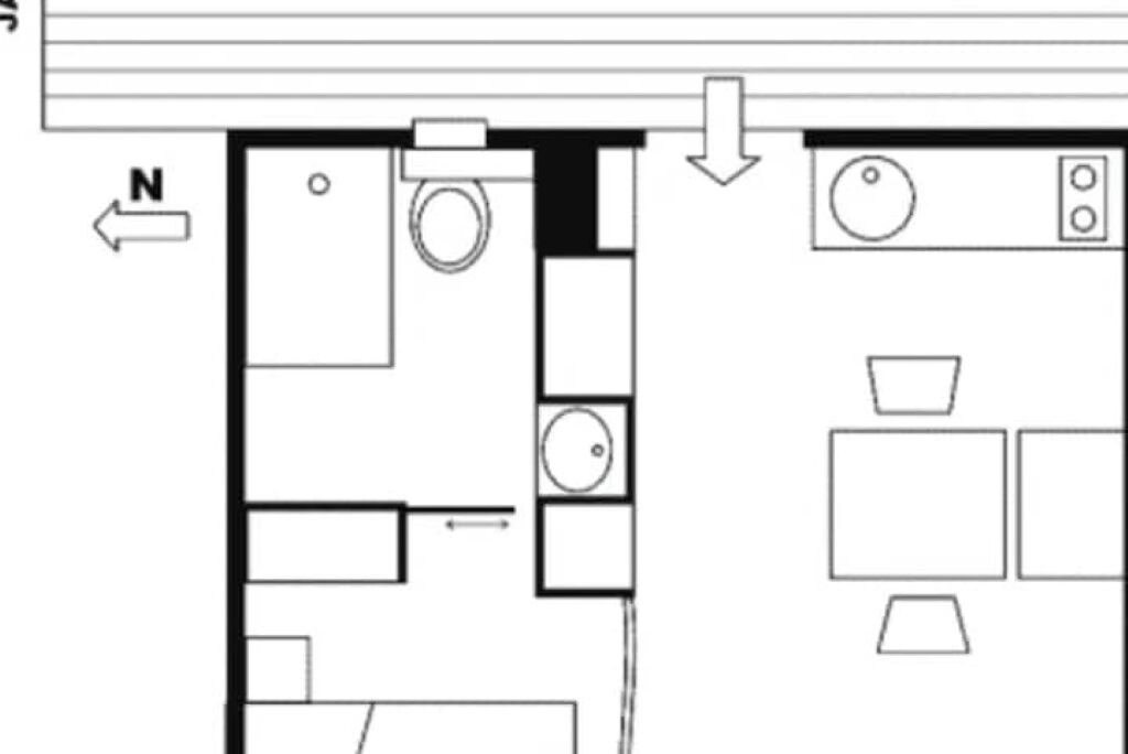 A floor plan of a hotel room with a bed, a desk, a chair, a window, and a bathroom.
