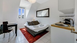 A modern bedroom with a bed, a desk, and a large window. - 26ROSIERS (Paris)