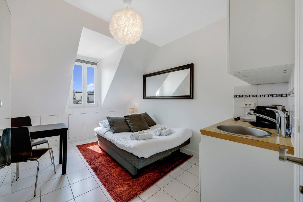 Une chambre moderne avec un lit, un bureau et une grande fenêtre.