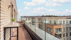 Ein modernes Gebäude mit einem Glasbalkon und Blick auf eine Stadtlandschaft.