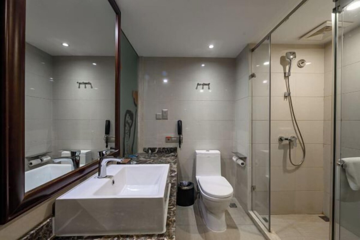 A modern bathroom with a large sink, toilet, and shower.