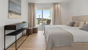 A modern bedroom with a bed, a desk, and a view of the outdoors.