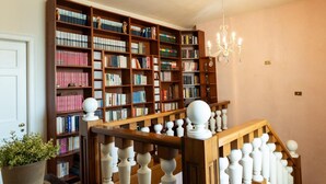 A library with wooden bookshelves and a chandelier.