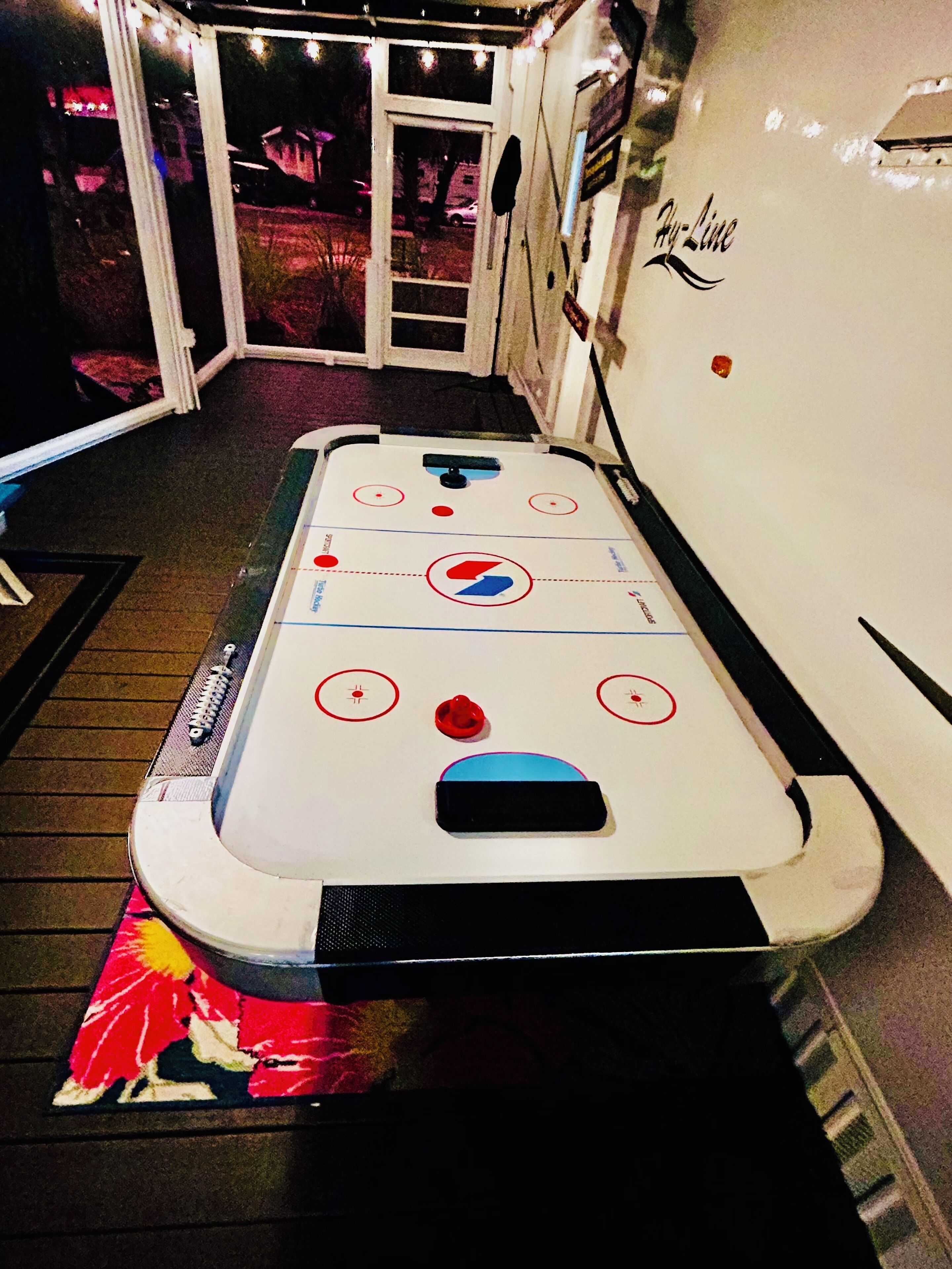 An indoor ice skating rink with a white surface, red and blue markings, and a black puck in the center.
