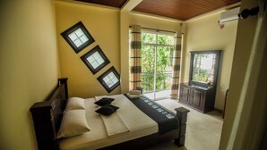 Ein Schlafzimmer mit Bett, Fenster, Schreibtisch und Deckenventilator.